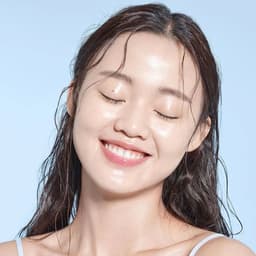 Modelo con piel radiante e hidratada usando COSRX Advanced Snail 92 All in One Cream, crema coreana con mucina de caracol disponible en Perú