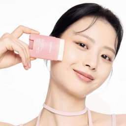 Modelo con piel mate sosteniendo Celimax Oil Control Mattifying Sun Stick, protector solar coreano matificante para piel grasa disponible en Perú