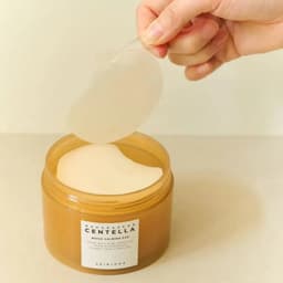 Pad calmante SKIN1004 Centella siendo extraído del envase, rutina de skincare coreano calmante en Perú